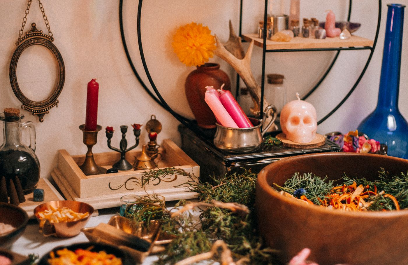 A candlelit altar arranged with crystal points, herbs, and vessels