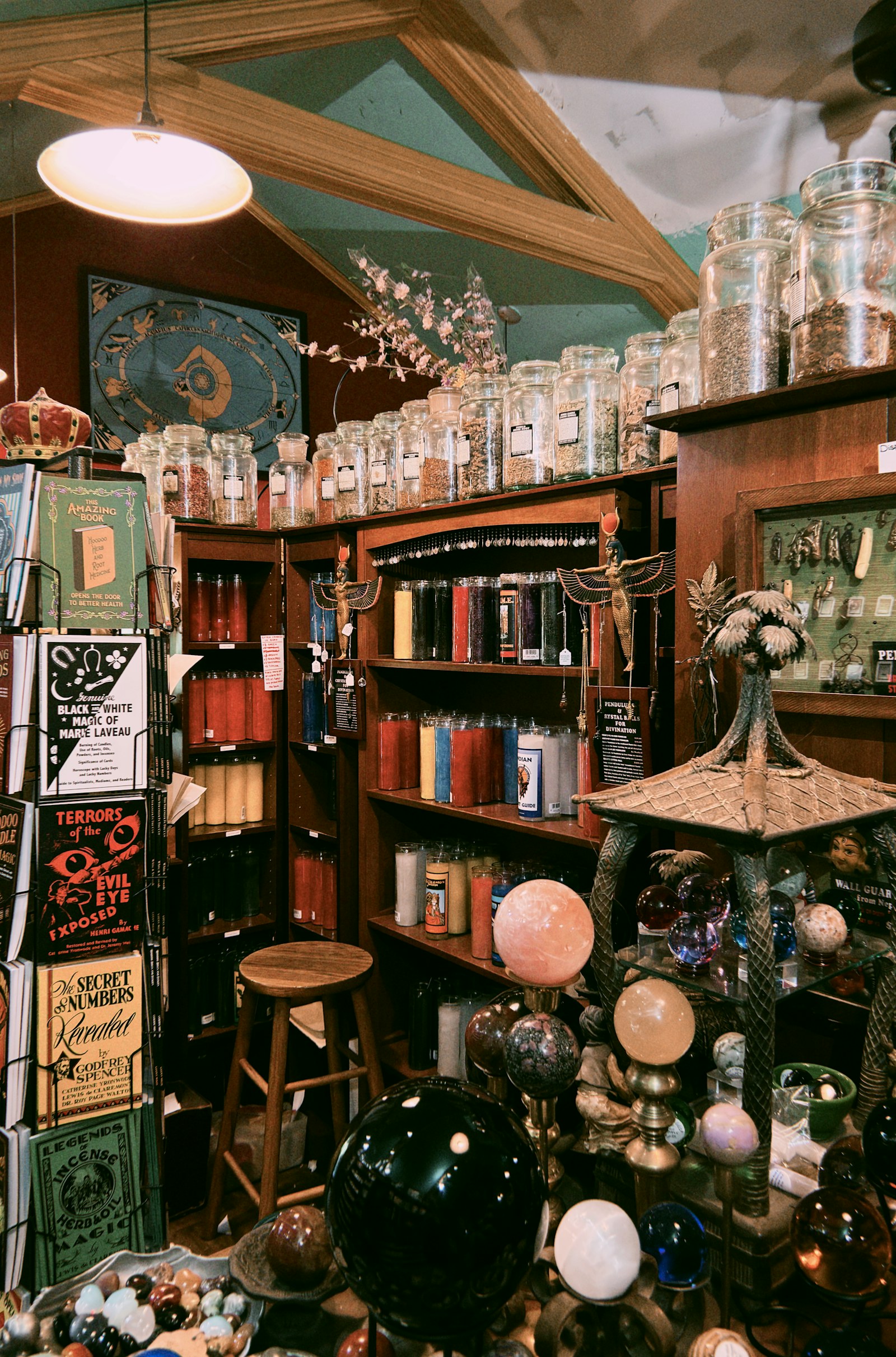 Shelves filled with candles, herbs, books, and crystals in a traditional mystical shop