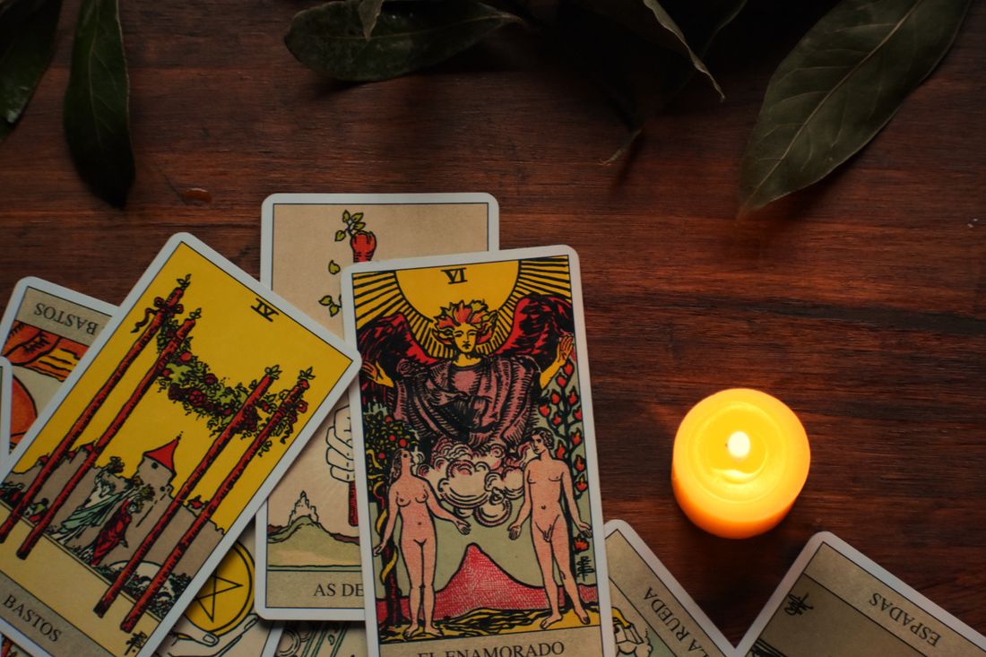 Tarot cards, a candle, and crystals arranged for reflection